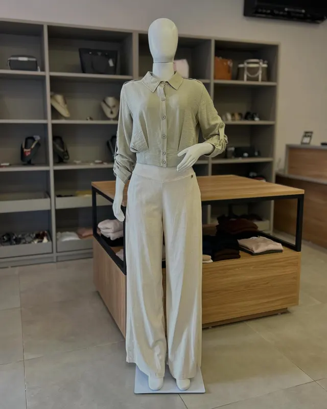 Conjunto verde-claro de camisa e pantalona, no manequim, dentro da loja